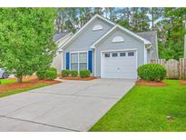 Charming home featuring a driveway and attached garage, complemented by a well-maintained lawn and colorful landscaping at 4831 Carnoustie Ct, Summerville, SC 29485