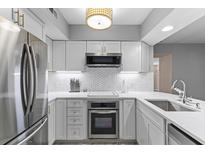 Bright, modern kitchen features white cabinetry, stainless steel appliances and white marble countertops at 55 Ashley Ave # 6, Charleston, SC 29401