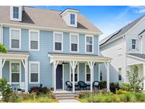 Charming blue two-story home with a inviting front porch, perfect for relaxing and enjoying the neighborhood at 557 Blueway Ave, Summerville, SC 29486