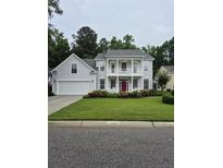 Charming two-story home with well-manicured lawn and inviting red front door at 605 Pointe Of Oaks Rd, Summerville, SC 29485
