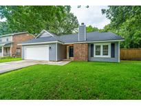 Charming single-story home featuring a well-manicured lawn, attached garage and brick chimney at 105 Glebe Rd, Summerville, SC 29485