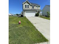 Charming two-story home featuring a two-car garage, manicured lawn, and classic architectural design at 1343 Discovery Dr, Ladson, SC 29456