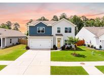 Charming two-story home featuring blue and gray siding, a two-car garage, and a well-maintained lawn at 141 Pine Crest View Dr, Summerville, SC 29486
