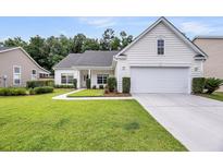 Charming one-story home featuring manicured lawn, tidy landscaping, and a two-car garage at 1445 Ashley Gardens Blvd, Charleston, SC 29414