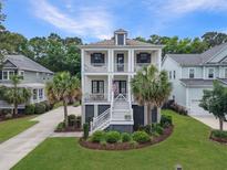 Charming two-story home with double front porches, landscaped yard, and palm trees at 1489 Red Tide Rd, Mount Pleasant, SC 29466