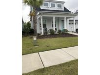 Charming home with a manicured lawn, inviting porch, and a vibrant blue front door at 1515 Pogonia St # 2, Mount Pleasant, SC 29466