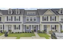 Charming townhome with a well-manicured lawn and covered front porch, perfect for relaxing outdoors at 208 Kirkland St, Goose Creek, SC 29445