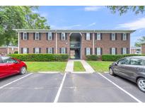 Brick apartment building exterior with parking and landscaping under a blue sky at 21 Rivers Point Row # 17G, Charleston, SC 29412