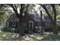 Charming brick home featuring a well-manicured lawn and mature trees providing shade at 218 Yates Ave, Charleston, SC 29412