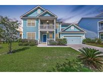 Charming two-story home featuring a double porch, blue siding, well-manicured lawn, and an attached two-car garage at 2336 Brinkley Rd, Johns Island, SC 29455