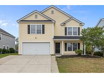 Charming two-story home featuring a classic design, attached garage and manicured landscaping at 251 Emerald Isle Dr, Moncks Corner, SC 29461