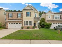 Charming two-story home featuring a two-car garage and a well-manicured lawn at 272 Overcup Loop, Summerville, SC 29486