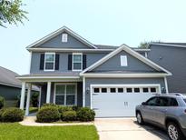 Charming two-story home with gray siding, a two-car garage, and well-maintained landscaping at 3254 Hartwell St, Johns Island, SC 29455