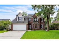 Charming two-story brick home featuring a well-manicured lawn and mature tree, offering classic curb appeal at 3290 Middleburry Ln, Charleston, SC 29414