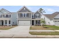 Charming two-story home with gray siding, a two-car garage, and a well-maintained front yard at 357 Hillman Trail Dr, Moncks Corner, SC 29461