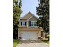 Charming two-story home with a two-car garage, neutral siding, and lush green trees, offering a welcoming curb appeal at 3706 Blackjack Rd, Ladson, SC 29456