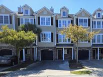 Charming townhome exterior with lush landscaping, garage, and black shutters at 4013 Conant Rd, Mount Pleasant, SC 29466