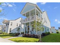 Charming two-story home with a double porch and swing, plus lush landscaping at 403 Cool Bend Ln, Summerville, SC 29486