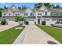 Charming townhomes with varied exterior colors, single car garages and well maintained landscaping at 409 Grand Palm Ln, Summerville, SC 29485