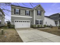 Two-story home featuring a two-car garage, neutral siding and black shutters, with a well manicured yard at 484 Whispering Breeze Ln, Summerville, SC 29486