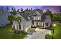 Charming two-story home featuring a well-maintained yard, palm trees, and inviting red front door at 626 Chigwell Springs Ln, Summerville, SC 29486