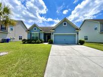 Charming blue home featuring manicured lawn and an attached two-car garage at 7629 High Maple Cir, North Charleston, SC 29418