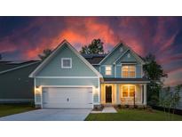 Charming two-story home with a two-car garage, a welcoming porch, and a beautifully landscaped yard at 770 Opal Wing St, Moncks Corner, SC 29461