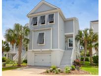 Charming elevated home with garage, staircase, palm trees, and neutral color scheme at 779 Forrest Dr, Charleston, SC 29492
