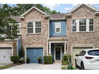 Charming townhome with stone facade, blue accents, two-car garage, and manicured landscaping at 826 Bibury Ct, Charleston, SC 29414