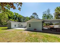 A well-maintained backyard features a patio and a covered area with outdoor seating, perfect for entertaining at 8562 N Highway 17, McClellanville, SC 29458