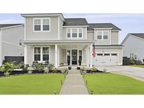 Inviting two-story home featuring a landscaped yard, covered porch, and attached two-car garage at 109 Medford St, Summerville, SC 29486