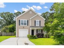 Charming two-story home with a well-maintained front yard, a single-car garage, and beautiful landscaping at 1170 Deerberry Rd, Hanahan, SC 29410