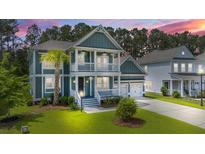 Inviting two-story home with a charming porch, lush lawn, and a well-manicured landscape at 183 Calm Water Way, Summerville, SC 29486