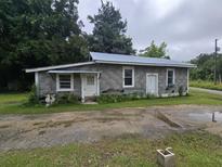 A gray block home with a metal roof, small yard, and two entry doors at 2200 State Road Rd, Summerville, SC 29486