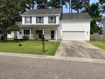 Charming two-story home with white siding, black shutters, well-maintained lawn, and attached garage at 243 Trickle Dr, Summerville, SC 29483