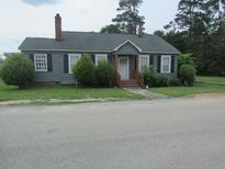 Charming single-story home with gray siding, a quaint porch, and well-manicured landscaping at 301 Ridge St, Saint George, SC 29477