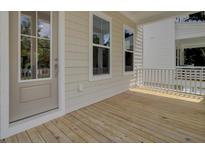 Inviting porch with wood flooring, bright windows, and neutral colored siding at 3027 Robeson Trce, Johns Island, SC 29455