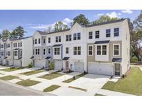 Modern townhome exterior featuring varied colors, multi-pane windows, and attached garages at 477 Caledon Ct, Johns Island, SC 29455