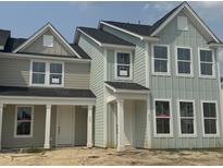Newly built townhomes boast light green siding, black roof, and white trim, creating a modern farmhouse appeal at 823 Alma Square Dr, Moncks Corner, SC 29461
