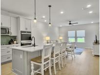 Bright, open kitchen featuring an island with seating, pendant lighting, and stainless steel appliances at 953 Dusk Dr, Summerville, SC 29486