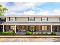 Inviting two-story townhome with a brick facade, cozy porch, and manicured landscaping at 1166 Julian Clark Rd, Charleston, SC 29412