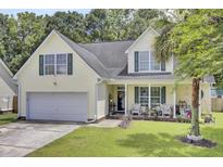 Charming two-story home with a well-manicured lawn and inviting front porch with seating at 172 Cotillion Cresent Cres, Summerville, SC 29483