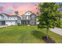 Charming two-story home featuring stone accents, a well-manicured lawn, and a cozy front porch at 223 Granton Edge Ln, Summerville, SC 29486