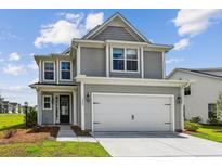 Charming two-story home featuring a two-car garage and manicured lawn under a bright, cloudy sky at 3802 Grateful Rd, North Charleston, SC 29420