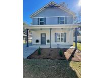 Charming two-story home featuring a cozy front porch and freshly landscaped yard at 405 Simmons Ave, Summerville, SC 29483