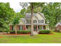 Charming two-story home featuring a well-manicured lawn and inviting front porch at 5195 Forest Oaks Dr, Hollywood, SC 29449