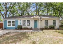 Charming single-story home with a light blue door, light yellow siding, and a well-maintained front yard at 5817 Canterbury Dr, Hanahan, SC 29410
