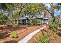 Charming home features a well-manicured lawn and a inviting walkway that leads to the front entrance at 622 E Cooper Ave, Folly Beach, SC 29439