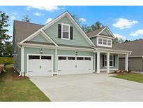 Charming two-story home features a large three car garage and manicured lawn at 769 Maynard Ln, Summerville, SC 29486