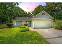 Charming single story home with light blue siding, manicured lawn and a two car garage at 8507 William Moultrie Dr, North Charleston, SC 29420